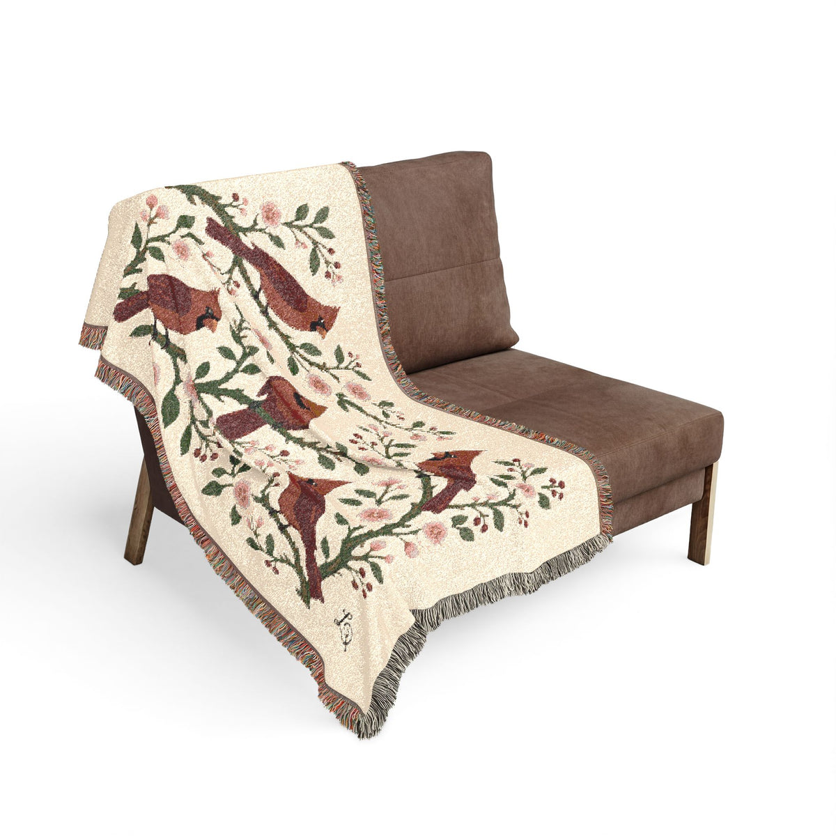 Winter Cardinals & Blossoms Woven Throw by LQ, draped over a chestnut-brown lounge chair, showing crimson cardinals and blossoms woven in cotton jacquard with fringed edges